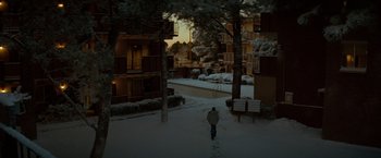 Movie still from “Let Me In” (2010), directed by Matt Reeves – A person walking on a snowy path near a building; Extreme Wide shot, High angle