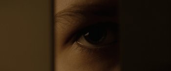 Movie still from “Let Me In” (2010), directed by Matt Reeves – A person's eye in a dark room; Extreme Close Up shot, Overhead angle