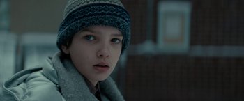 Movie still from “Let Me In” (2010), directed by Matt Reeves – A young boy wearing a hat and a scarf; Close Up shot, Low angle