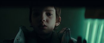 Movie still from “Let Me In” (2010), directed by Matt Reeves – A young boy is looking at the camera; Close Up shot, Low angle