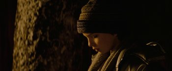 Movie still from “Let Me In” (2010), directed by Matt Reeves – A woman wearing a hat and a scarf looking to her left; Close Up shot, Low angle