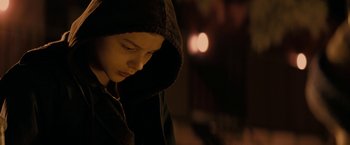Movie still from “Let Me In” (2010), directed by Matt Reeves – A young boy wearing a hooded jacket looking down; Close Up shot, Low angle