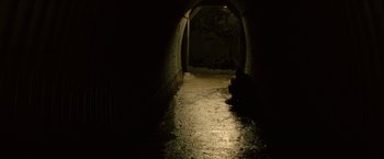 Movie still from “Let Me In” (2010), directed by Matt Reeves – A person sitting in the dark in a tunnel; Extreme Wide shot, High angle