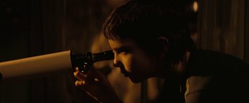 Movie still from “Let Me In” (2010), directed by Matt Reeves – A young boy looking through a telescope at night; Extreme Close Up shot, Over the shoulder angle