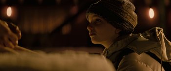 Movie still from “Let Me In” (2010), directed by Matt Reeves – A young boy wearing a winter hat looking off into the distance; Close Up shot, Over the shoulder angle