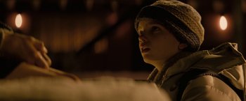 Movie still from “Let Me In” (2010), directed by Matt Reeves – A young boy wearing a hat looking to his left; Close Up shot, Low angle