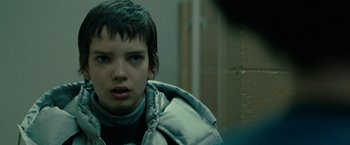 Movie still from “Let Me In” (2010), directed by Matt Reeves – A young boy wearing a silver jacket and looking at the camera; Close Up shot, Over the shoulder angle