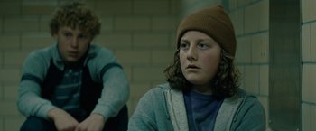 Movie still from “Let Me In” (2010), directed by Matt Reeves – A young person wearing a hat and a sweater; Close Up shot, Over the shoulder angle