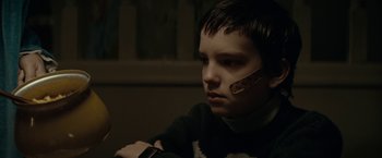 Movie still from “Let Me In” (2010), directed by Matt Reeves – A boy with a bandage on his face; Close Up shot, Over the shoulder angle