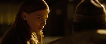 Movie still from “Let Me In” (2010), directed by Matt Reeves – A young girl is looking at the camera; Close Up shot, Over the shoulder angle