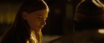 Movie still from “Let Me In” (2010), directed by Matt Reeves – A young girl is looking at the camera; Close Up shot, Over the shoulder angle