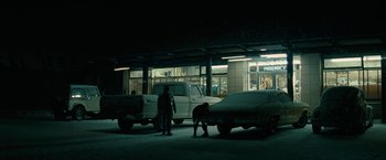 Movie still from “Let Me In” (2010), directed by Matt Reeves – Two men are standing in front of a truck; Extreme Wide shot, Low angle
