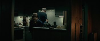 Movie still from “Let Me In” (2010), directed by Matt Reeves – A man and a woman standing in a kitchen; Medium shot, Over the shoulder angle
