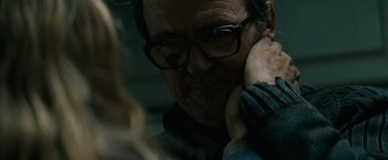 Movie still from “Let Me In” (2010), directed by Matt Reeves – An older man wearing glasses looking at the camera; Close Up shot, Over the shoulder angle