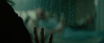 Movie still from “Let Me In” (2010), directed by Matt Reeves – A person's hand is seen through a glass window; Extreme Close Up shot, Over the shoulder angle