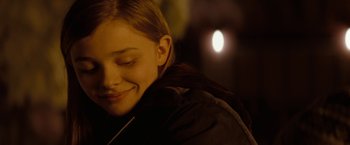 Movie still from “Let Me In” (2010), directed by Matt Reeves – A young girl smiling with her eyes closed; Close Up shot, Over the shoulder angle