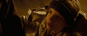 Movie still from “Let Me In” (2010), directed by Matt Reeves – A young woman wearing a winter coat and a hat; Close Up shot, Low angle