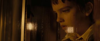 Movie still from “Let Me In” (2010), directed by Matt Reeves – A young woman looking out of a window at night; Extreme Close Up shot, Over the shoulder angle