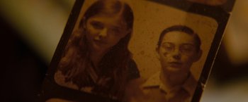 Movie still from “Let Me In” (2010), directed by Matt Reeves – An old photo of a woman and a man; Extreme Close Up shot, High angle