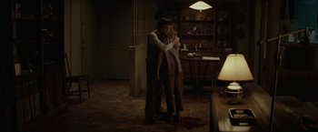 Movie still from “Let Me In” (2010), directed by Matt Reeves – A man and a woman hugging in a living room; Wide shot, High angle