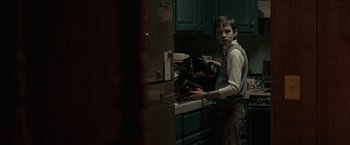 Movie still from “Let Me In” (2010), directed by Matt Reeves – A young boy standing in front of a kitchen counter; Medium shot, Over the shoulder angle