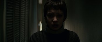 Movie still from “Let Me In” (2010), directed by Matt Reeves – A young boy with short black hair stares into the camera; Close Up shot, Low angle