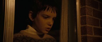 Movie still from “Let Me In” (2010), directed by Matt Reeves – A young boy is looking down at his face; Close Up shot, Low angle