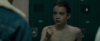 Movie still from “Let Me In” (2010), directed by Matt Reeves – A young girl holding a pair of scissors in front of a mirror; Close Up shot, Over the shoulder angle