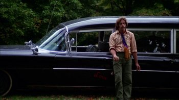 Movie still from “Let's Scare Jessica to Death” (1971), directed by John D. Hancock – A man standing in front of an old black car; Wide shot, Low angle