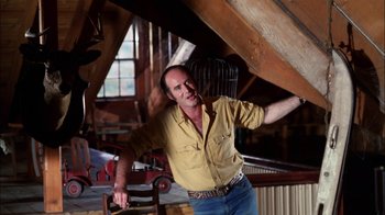 Movie still from “Let's Scare Jessica to Death” (1971), directed by John D. Hancock – A man in a yellow shirt is standing in a room; Medium shot, Low angle