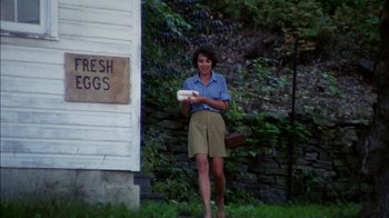 Movie still from “Let's Scare Jessica to Death” (1971), directed by John D. Hancock – A woman standing in front of a building holding something; Wide shot, High angle
