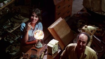Movie still from “Let's Scare Jessica to Death” (1971), directed by John D. Hancock – A woman sitting at a table in front of a lamp; Medium shot, High angle
