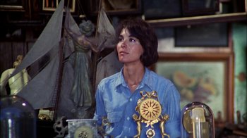 Movie still from “Let's Scare Jessica to Death” (1971), directed by John D. Hancock – A woman sitting in front of a statue holding an alarm clock; Medium shot, High angle
