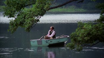 Movie still from “Let's Scare Jessica to Death” (1971), directed by John D. Hancock – A man sitting in a boat on a lake; Wide shot, High angle