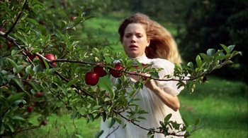 Movie still from “Let's Scare Jessica to Death” (1971), directed by John D. Hancock – A young woman standing next to an apple tree; Medium shot, High angle