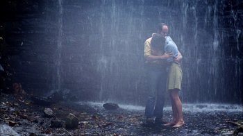 Movie still from “Let's Scare Jessica to Death” (1971), directed by John D. Hancock – A man and a woman hugging in front of a waterfall; Wide shot, High angle