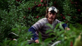 Movie still from “Let's Scare Jessica to Death” (1971), directed by John D. Hancock – A man with a gas mask is sitting in the bushes; Medium shot, Low angle