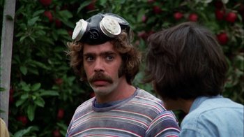 Movie still from “Let's Scare Jessica to Death” (1971), directed by John D. Hancock – A man with a gas mask on his head; Close Up shot, Over the shoulder angle
