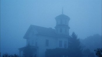 Movie still from “Let's Scare Jessica to Death” (1971), directed by John D. Hancock – A white house with a large tower in the middle of a foggy day; Extreme Wide shot, Low angle