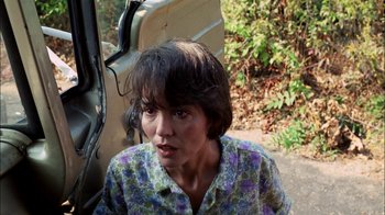 Movie still from “Let's Scare Jessica to Death” (1971), directed by John D. Hancock – A woman sitting in front of a car on the side of the road; Close Up shot, High angle