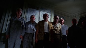 Movie still from “Let's Scare Jessica to Death” (1971), directed by John D. Hancock – A group of men standing next to each other in a room; Wide shot, Low angle