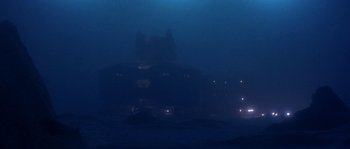 Movie still from “Leviathan” (1989), directed by George P. Cosmatos – A building in the middle of the night with lights on; Extreme Wide shot, Low angle