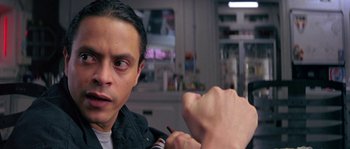 Movie still from “Leviathan” (1989), directed by George P. Cosmatos – A man is looking into the camera while another man holds his hand out; Close Up shot, Low angle