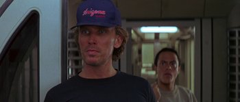 Movie still from “Leviathan” (1989), directed by George P. Cosmatos – A man wearing a hat standing next to another man; Close Up shot, Over the shoulder angle