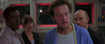 Movie still from “Leviathan” (1989), directed by George P. Cosmatos – A man with a surprised look on his face in front of two other people; Close Up shot, Over the shoulder angle