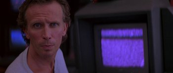 Movie still from “Leviathan” (1989), directed by George P. Cosmatos – A person in front of a television; Close Up shot, Over the shoulder angle