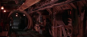 Movie still from “Leviathan” (1989), directed by George P. Cosmatos – The interior of an industrial building with pipes and wires; Wide shot, High angle