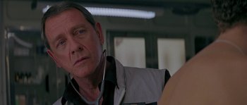 Movie still from “Leviathan” (1989), directed by George P. Cosmatos – An older man with a stethoscope around his neck; Close Up shot, Over the shoulder angle