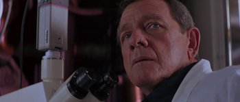 Movie still from “Leviathan” (1989), directed by George P. Cosmatos – An older man looking into a microscope; Close Up shot, Low angle