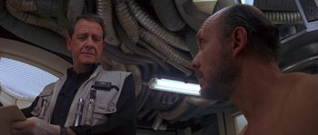 Movie still from “Leviathan” (1989), directed by George P. Cosmatos – Two men are looking at each other in a building; Close Up shot, Low angle